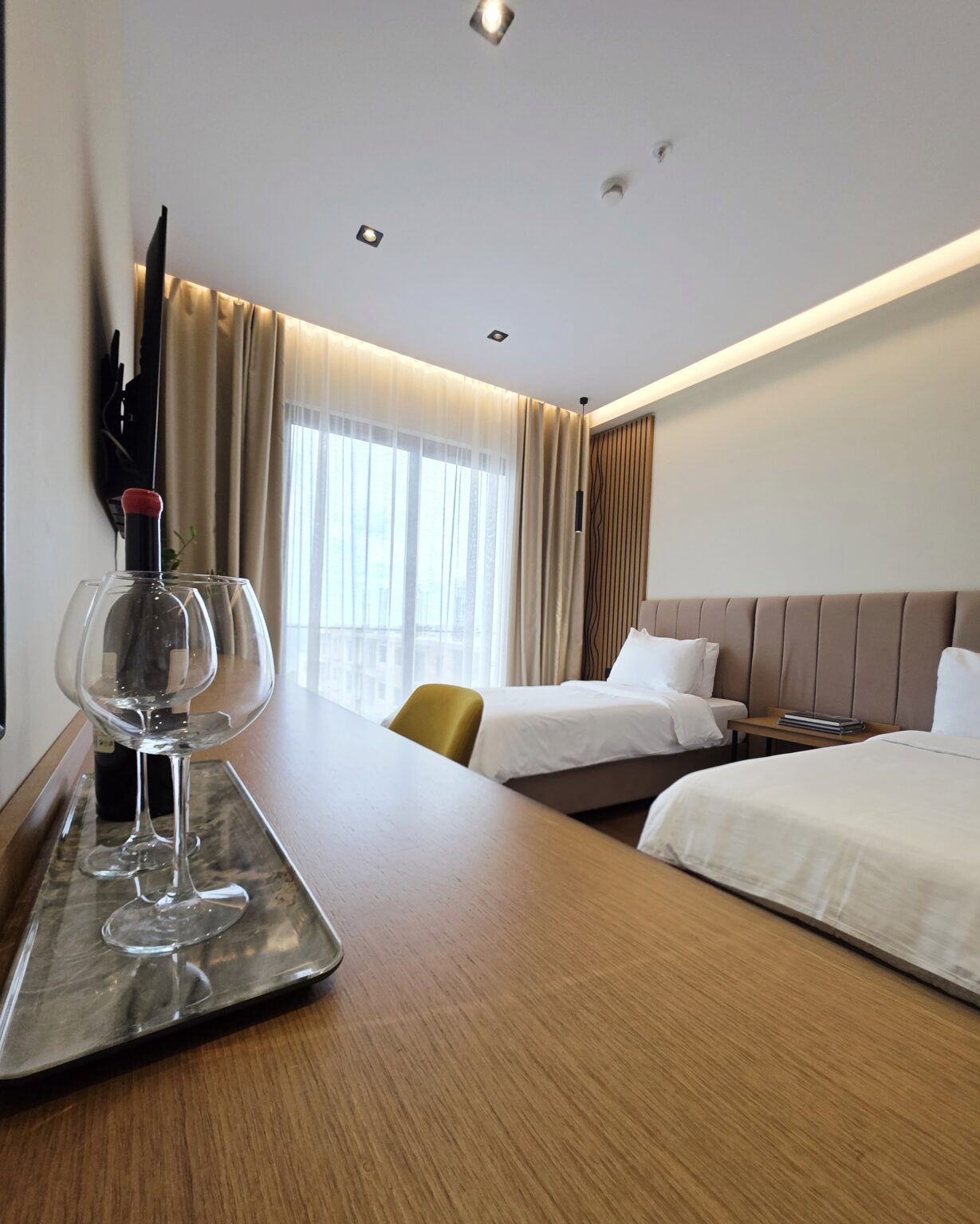 Twin Deluxe Room at Valza Boutique Hotel with two single beds, wooden desk and mustard velvet chair