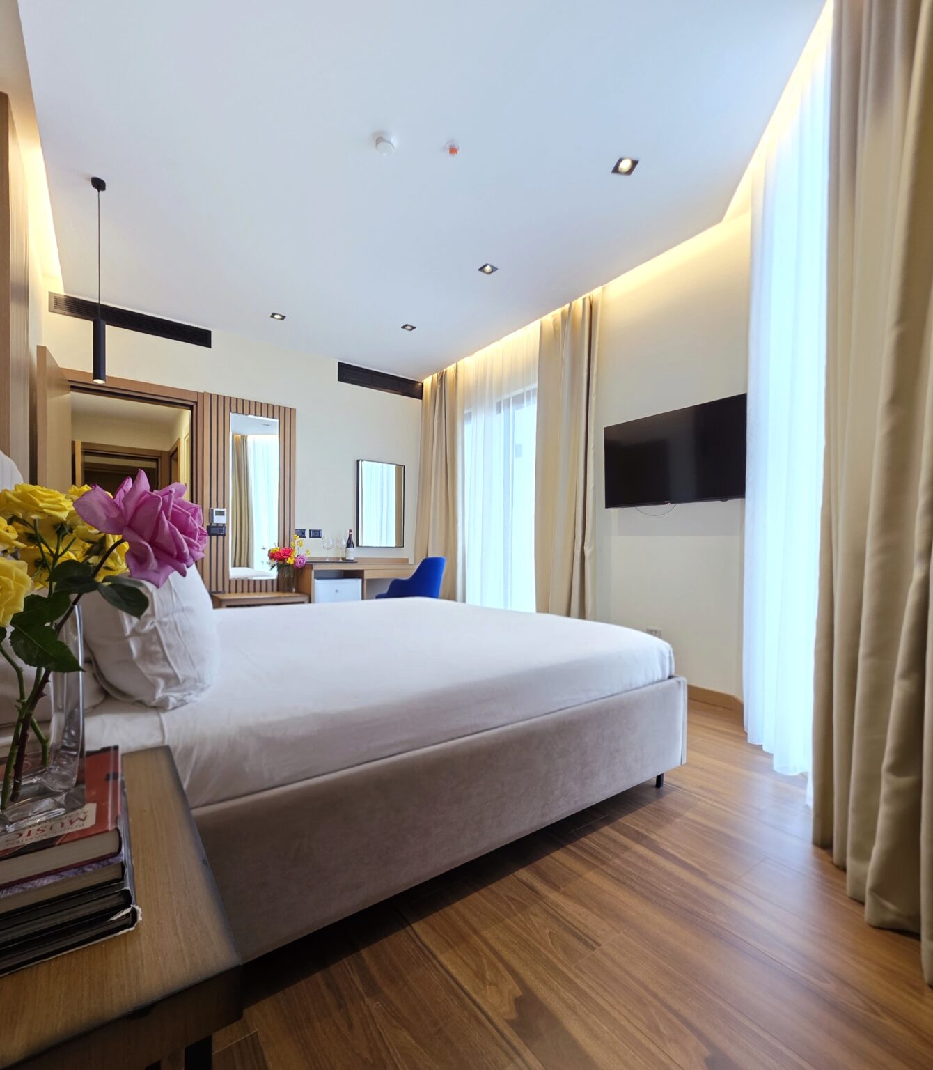 Family Suite master bedroom at Valza Boutique Hotel Vlorë with a double bed, desk, blue armchair and wall-mounted TV