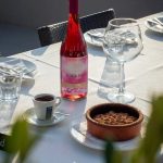 EdenRooftopRestaurant-Valza-04 Bottle of Albanian rosé wine, an espresso and a cocoa-dusted dessert in a clay dish on a sunlit table