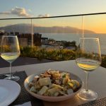 EdenRooftopRestaurant-Valza-05 Cheese and crouton salad with two glasses of white wine on the Eden by Valza rooftop at sunset