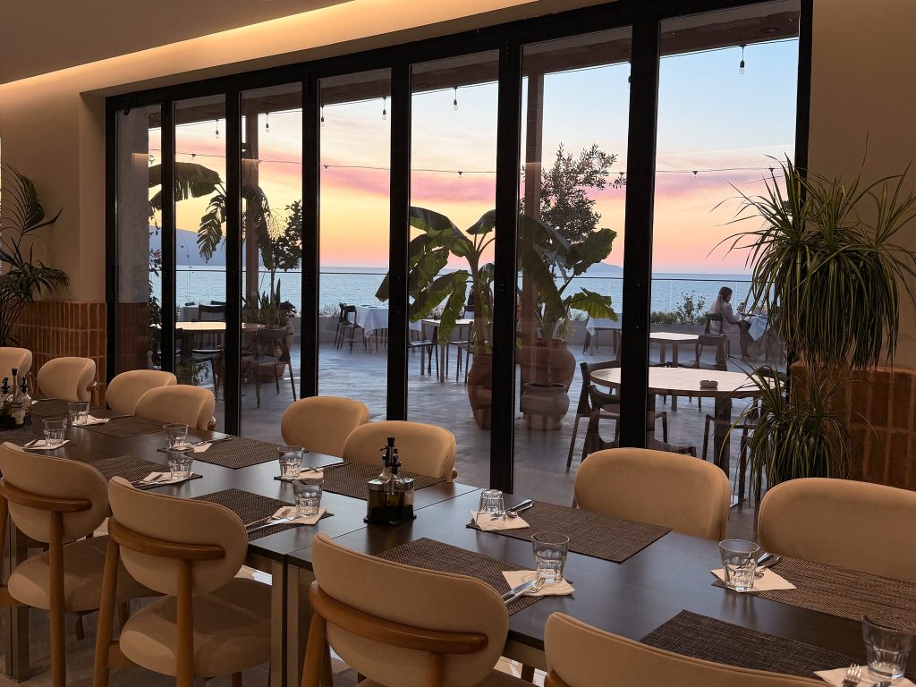 thumbnail restaurant Eden by Valza dining room with set tables and folding glass doors open to the terrace at sunset